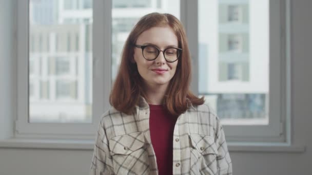 Chica nerd en gafas sonríe alegremente y posa — Vídeos de Stock