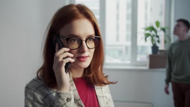 Mädchen mit Brille beschwert sich am Telefon über ihren Freund — Stockvideo