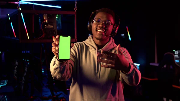 Tanınmış bir flama makinesi elinde yeni bir akıllı telefon modeli tutuyor ve onu tanıtıyor.