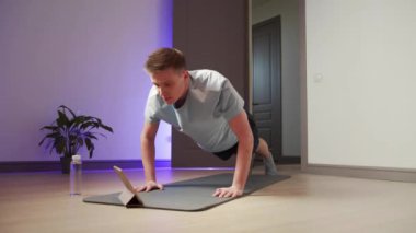 Bir erkek şınav çeker ve kolayca pilates yapar.