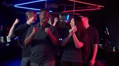 Üç erkek ve bir Asyalı kız anı fotoğrafı çektirdikten sonra zafere sevinir ve birbirlerine sarılırlar.