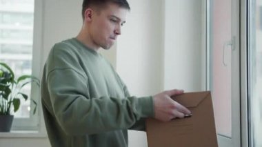 Öğrenci kutuyu pencere eşiğine koyar ve içindeki kitapları çıkarır.