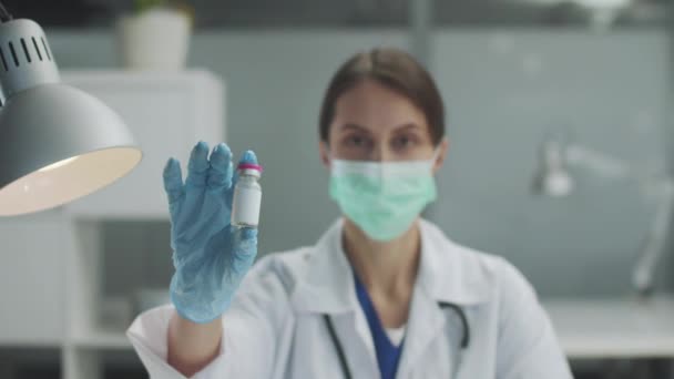 用年轻女医生的手拿着疫苗或药物的瓶子的特写 — 图库视频影像