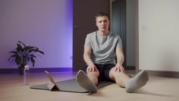 Il ragazzo durante lo yoga sta lottando per raggiungere le dita dei piedi — Video Stock