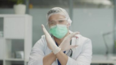 Deneyimli bir doktor kanıtlanmamış etkinliği nedeniyle bu ilacın aşılanmasını yasaklıyor. Kliniğin içinde, ön planda sahte bir aşı bulunan bir şişe, yavaş çekim..