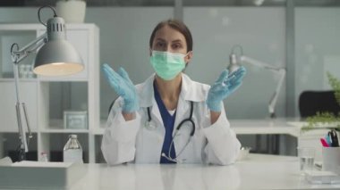 Klinikte tıbbi bir randevu sırasında, kadın bir doktor, hastanın tıbbi geçmişini ayakta duran bir masada, ağır çekimde alır..