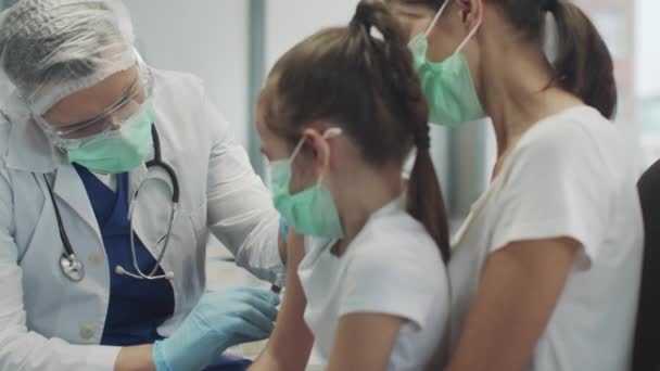 Mam bracht haar dochtertje naar de kliniek voor vaccinatie, na de vaccinatie prees de dokter het kleine meisje, slowmotion. — Stockvideo