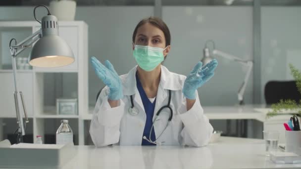 Lors d'un rendez-vous médical à la clinique, une femme médecin recueille les antécédents médicaux des patients à une table debout, au ralenti. — Video
