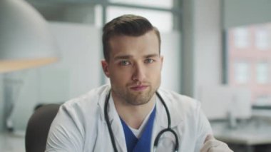 Hastane ofisindeki yorgun bir doktorun duygusal portresi. Doğrudan kameraya bak. Tehlikeli bir virüse karşı korunma aracı..