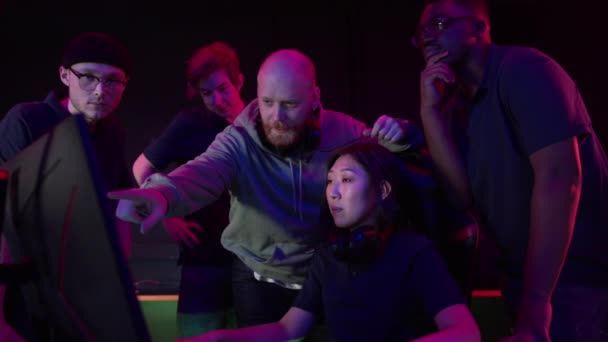 Een cyber team van jongens en een coach legt hun strategie uit aan een nieuw teamlid een Aziatisch meisje, slow motion — Stockvideo