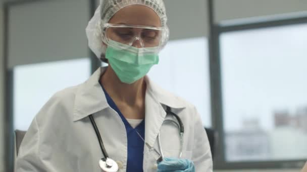 Procedurální sestra se připravuje na zavedení vakcíny, uvolňuje vzduch z injekční stříkačky a otírá pacientovi ruku antiseptickým zpomalením. — Stock video