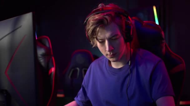 Під час участі в кіберспортивному турнірі молодий геймер отримав телефонний дзвінок, він говорить, сидячи за комп'ютером — стокове відео