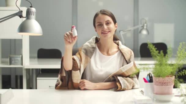 Mladá žena v kanceláři s dekou na ramenou doporučuje nechat se očkovat koronavirovou vakcínou. — Stock video