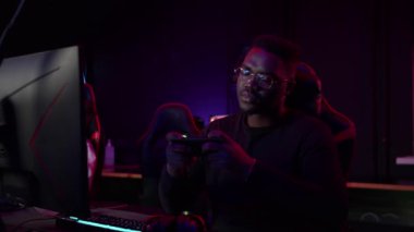 Bilgisayar oyunundan uzaklaşmak için siyah adam ara verdi ve oyun sandalyesindeki akıllı telefonla oynadı.