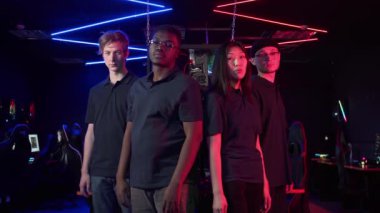 Büyük Esport Turnuvası 'nda takımları temsil etmek için çok uluslu erkekler ve bir kız kameraya bakıp kollarını göğüslerinin üstüne koyuyorlar.