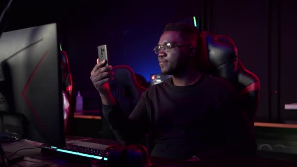 En afrikansk kille pratar på en videolänk med sina vänner i en datorklubb — Stockvideo