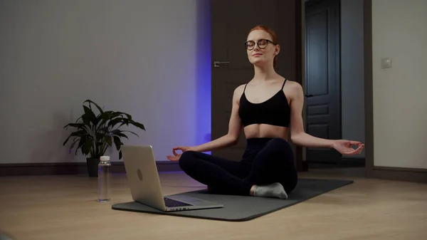 Ragazza con gli occhiali meditando mentre seduto sul pavimento — Foto Stock