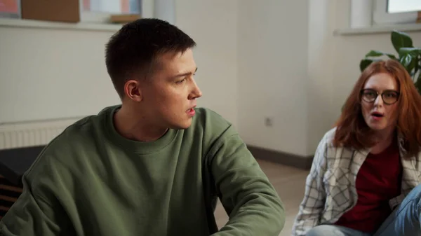 Kadın genç bir adama bağırıyor ve ona bir şeyler fırlatıyor.