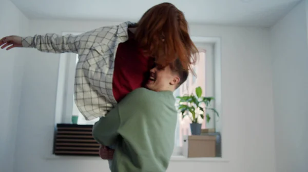 Un hombre abraza a una mujer y gira con ella en una habitación vacía. Moción lenta — Foto de Stock