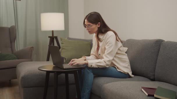 Молода бізнес-леді працює на ноутбуці і п'є каву . — стокове відео