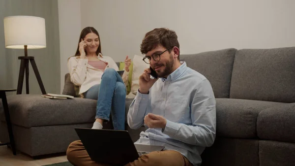 Белый европейский мужчина и женщина разговаривают по телефону в комнате — стоковое фото