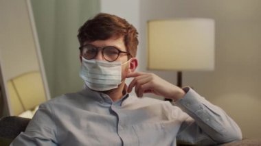 Avrupalı adam maskesini çıkarıp kameraya gülümsüyor.