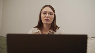 Ciddi bir Avrupalı kız bilgisayarda video bağlantısı kuruyor..