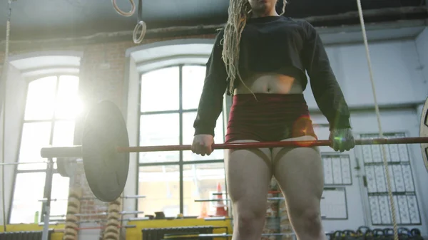 Una mujer atlética está haciendo barbell deadlift — Foto de Stock