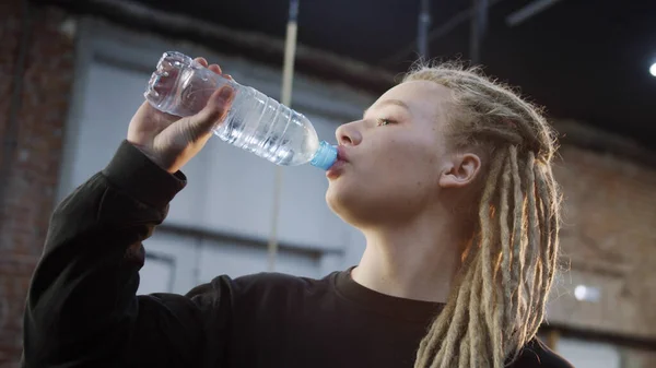 Uma desportista forte está a beber água — Fotografia de Stock