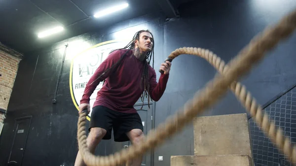 Un atlético hace ejercicio con cuerdas deportivas. — Foto de Stock