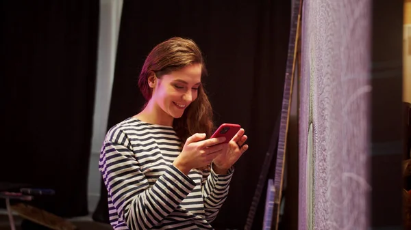 Un joven pintor está eligiendo una foto de cuadros hechos —  Fotos de Stock