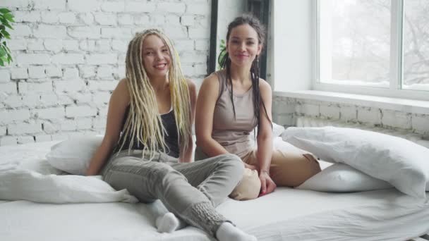 สาวหล่อสองคนบนเตียง นั่งบนแผ่นสีขาว — วีดีโอสต็อก