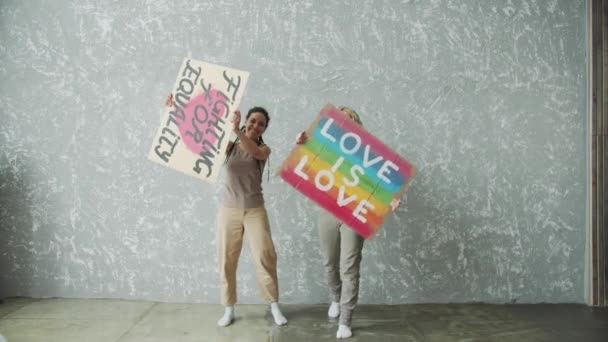 Chicas bailando súper divertidas con carteles LGBTQ — Vídeo de stock