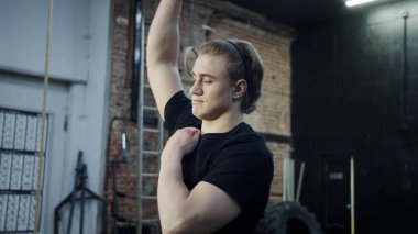 Güçlü bir atletik adam ellerini kaldırıyor.