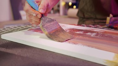 Bir adam fırçayla resim yapıyor. 