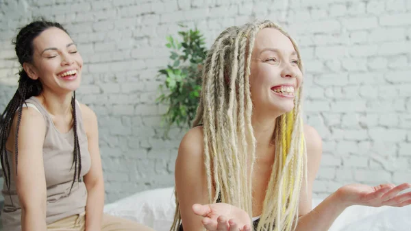 Delighted blond meisje vertelt een grap aan haar vriendin — Stockfoto
