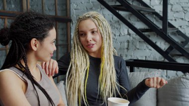 İki uzun saçlı kız, modern iç mekanla evde dinleniyor..