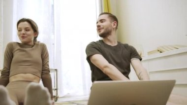 İki arkadaş konuşuyor ve esnek egzersizler yapıyorlar.