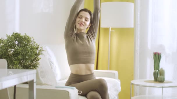 An attractive woman is stretching and raising up her hands — Stock Video