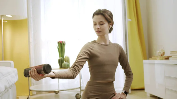 Eine sportliche Frau macht eine Übung mit einer Flasche — Stockfoto