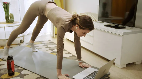 Sportif bir kadın internette sağlıklı egzersizler yapıyor. — Stok fotoğraf