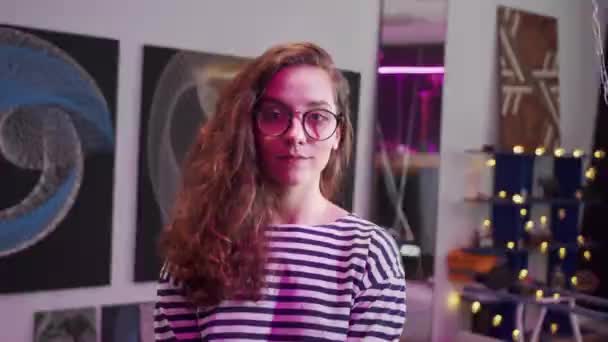 Eine junge Frau lächelt und blickt in die Kamera — Stockvideo