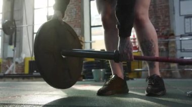 A strong athletic woman is preparing a barbell for her workout