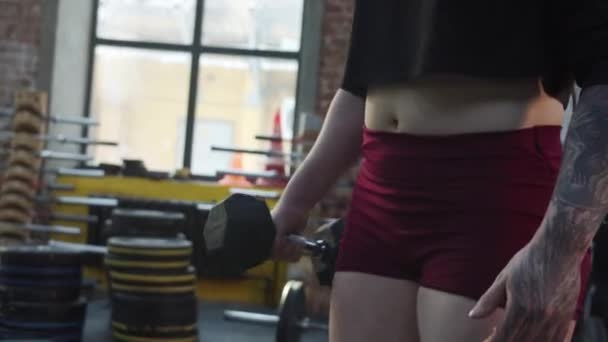 強い運動能力を持つ女性がダンベルで運動をしている — ストック動画