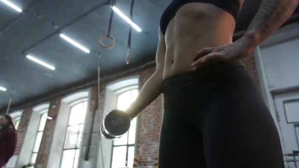 Uma mulher atlética forte está fazendo um exercício com um halteres — Vídeo de Stock