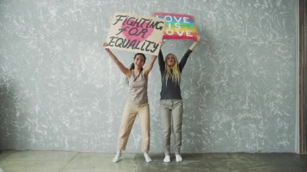 Glada flickor med dreadlocks viftar och dansar med färgglada affischer — Stockvideo