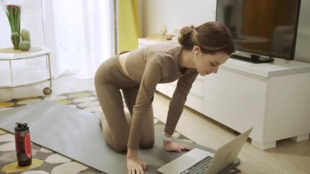 Sportif bir kadın internette sağlıklı egzersizler yapıyor. — Stok video