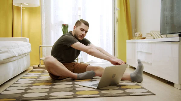 Привлекательный молодой человек делает здоровые упражнения в Интернете — стоковое фото