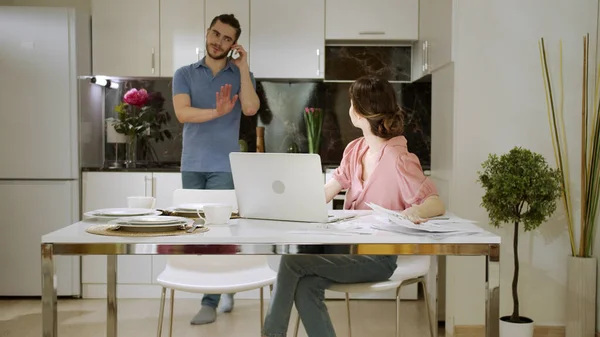 Un marido no deja que su esposa se concentre en su trabajo debido a su conversación — Foto de Stock