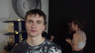 Genç adam, arkadaşları selfie çekerken kameraya konuşuyor.